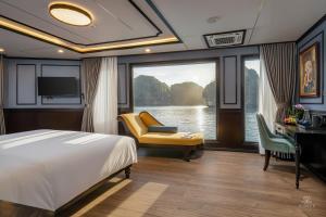 a bedroom with a bed and a desk and a window at AIME'E CRUISES - Halong Bay in Ha Long