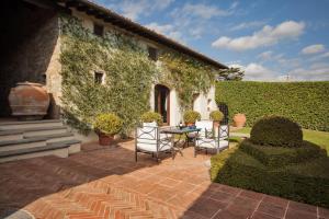 a patio with a table and chairs in front of a building at Villa privata per famiglie o amici in Barberino di Val dʼElsa