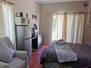 a bedroom with a bed and a chair and a microwave at Zonneblom Guest House in Middelburg
