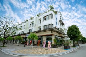 a large white building with people in front of it at EcoHouse Boutique Hotel Huế in Hue