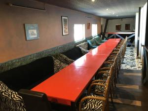 eine Reihe von roten Tischen und Stühlen in einem Restaurant in der Unterkunft Tolli Hostel & Holiday House in Valga