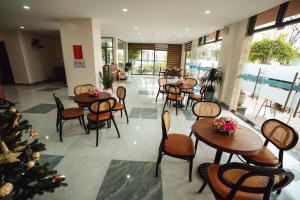a restaurant with tables and chairs and a christmas tree at EcoHouse Boutique Hotel Huế in Hue