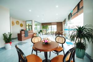 a room with a table and chairs with flowers on it at EcoHouse Boutique Hotel Huế in Hue