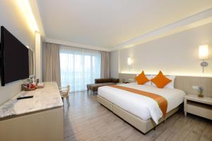 a hotel room with a large bed and a television at Hisea Huahin Hotel in Hua Hin