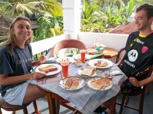 a man and a woman sitting at a table with food at Queen Villa in Bentota