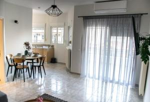 a dining room and kitchen with a table and chairs at Faros AXD Apartment in Alexandroupoli