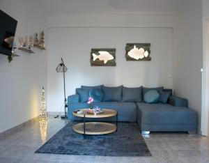 a living room with a blue couch and a table at Faros AXD Apartment in Alexandroupoli