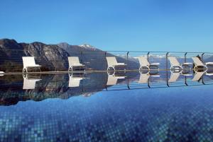 un grupo de sillas sentadas sobre una piscina de agua en Borgo Le Terrazze en Bellagio