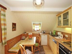 a kitchen with a wooden table and a table and chairs at Peaceful Cottage near Ski Area in Gmünd in Gmünd in Kärnten