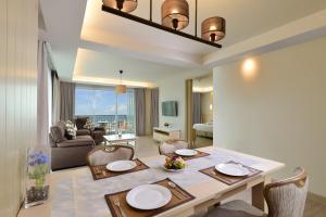a dining room and living room with a table and chairs at Hisea Huahin Hotel in Hua Hin