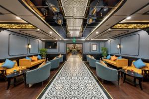 a train room with tables and chairs and a corridor at AIME'E CRUISES - Halong Bay in Ha Long
