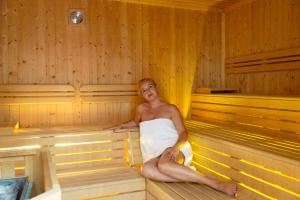 a man is sitting in a sauna at Hotel Columbia Terme in Abano Terme