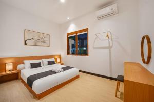 a bedroom with a bed and a desk and a window at Kuma Villa Bandung in Bandung