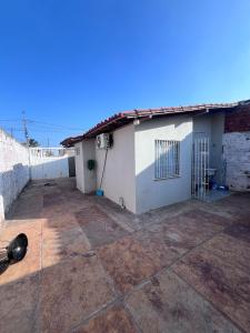 a small white house with a tile patio at Casa Barreirinhas in Barreirinhas