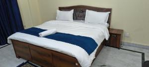 a bed with a blue and white blanket on it at Pb Legacy hotel in Noida +13 photos