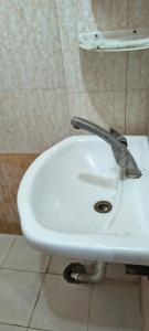 a white toilet in a bathroom with a sink at Pb Legacy hotel in Noida