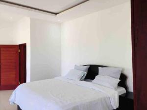 a bedroom with a bed with white sheets and pillows at Villa with 4 bedrooms in Lusaka