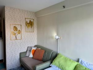 a living room with a couch and a wall at Unit 28 Mountain View Studio by Ems in Dumaguete