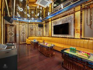 a lobby with a yellow couch and a television at AIME'E CRUISES - Halong Bay in Ha Long