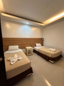 a room with two beds with towels on them at Pietros Square in Butuan +2 photos