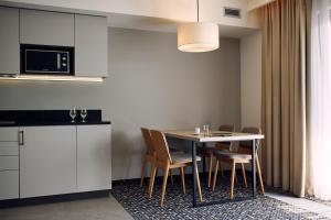 a kitchen and dining room with a table and chairs at Bristol Aparthotel in Busko-Zdrój