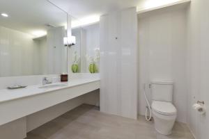 a white bathroom with a toilet and a sink at Hisea Huahin Hotel in Hua Hin