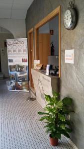 a shop with a clock on the wall and a plant at Hostal Boutique El Patio Lepe in Lepe