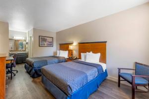 a hotel room with two beds and a desk at Rodeway Inn at Nevada State Capitol in Carson City