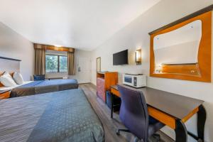 a hotel room with two beds and a desk at Rodeway Inn at Nevada State Capitol in Carson City +19 photos