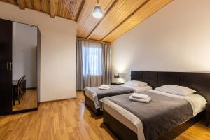 a bedroom with two beds and a large window at Hotel Chubu in Mestia