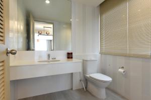a white bathroom with a toilet and a sink at Hisea Huahin Hotel in Hua Hin