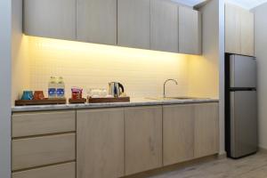 a kitchen with wooden cabinets and a sink at Hisea Huahin Hotel in Hua Hin