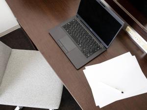 a laptop computer sitting on top of a wooden desk at Comfort Hotel Central International Airport in Tokoname