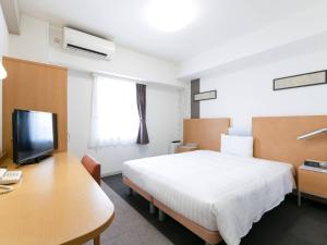 a hotel room with a bed and a desk and a tv at Comfort Hotel Central International Airport in Tokoname +33 photos
