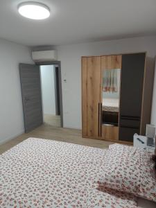 a white bedroom with a bed and a wooden closet at Villa Germini in Polje Čepić