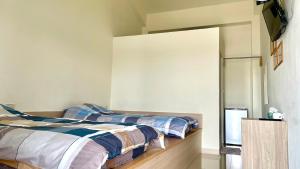 two beds sitting next to each other in a bedroom at 宜蘭好窄平價民宿 in Zhuangwei +17 photos