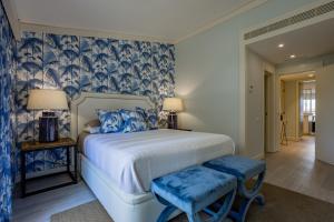 a bedroom with a large bed with blue and white patterns at The Palm Nest in Quinta do Lago +14 photos