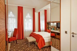 a hotel room with a bed and a desk at H+ Hotel Lübeck in Lübeck +19 photos