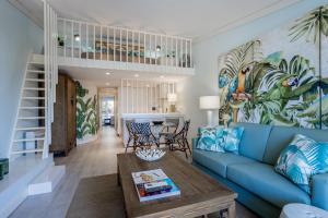 a living room with a blue couch and a table at The Palm Nest in Quinta do Lago