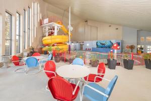 a room with a table and chairs and a slide at Clarion Pointe Medicine Hat Saamis Tepee in Medicine Hat