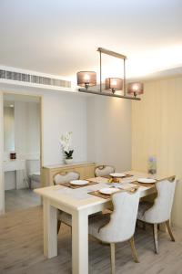 a dining room table with chairs and a light fixture at Hisea Huahin Hotel in Hua Hin