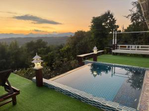 a swimming pool with a view of the mountains at Wanwan Lanna By Pat in Ban Huai Thong