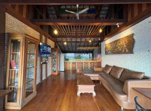 a living room with a couch and a table at Wanwan Lanna By Pat in Ban Huai Thong