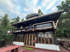 a building with glass doors and a balcony at Wanwan Lanna By Pat in Ban Huai Thong