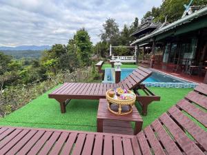 a picnic table with a basket of flowers next to a pool at Wanwan Lanna By Pat in Ban Huai Thong +6 photos