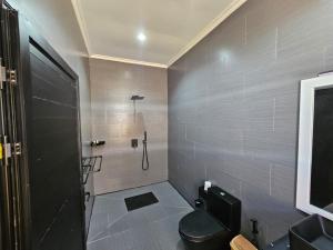 a bathroom with a black toilet and a shower at Vahinn Resort in Fort Dauphin