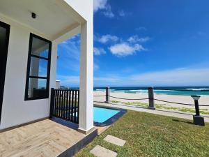 a house with a swimming pool and a view of the beach at Vahinn Resort in Fort Dauphin