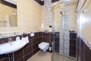 a bathroom with a toilet and a sink and a shower at Agancsos Panzió Villány in Villány +10 photos