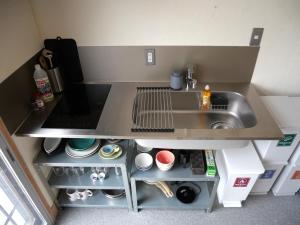 a small kitchen with a sink and an open refrigerator at HITOYANE guesthouse-1日1組限定- in Aizuwakamatsu +48 photos