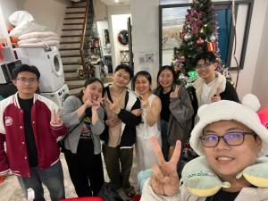 a group of people standing in front of a christmas tree at 29 Homestay Cầu Giấy in Hanoi